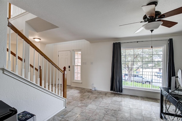 entryway with ceiling fan and a textured ceiling