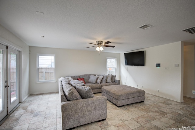 living room featuring a textured ceiling and ceiling fan