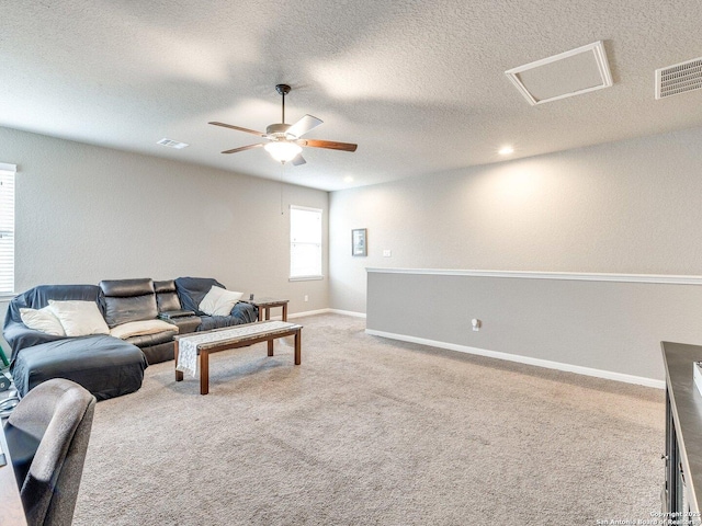 living room featuring ceiling fan, carpet, and a textured ceiling