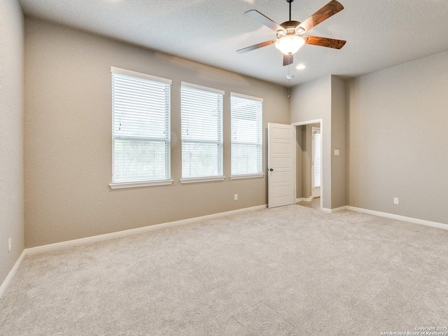 carpeted spare room with ceiling fan