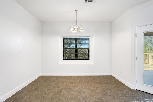 spare room with a notable chandelier and a wealth of natural light