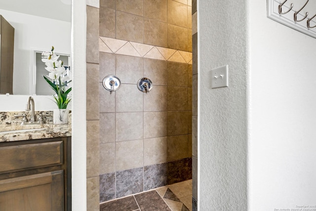 bathroom with vanity and tiled shower