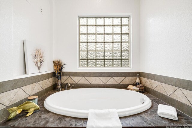 bathroom with a relaxing tiled tub