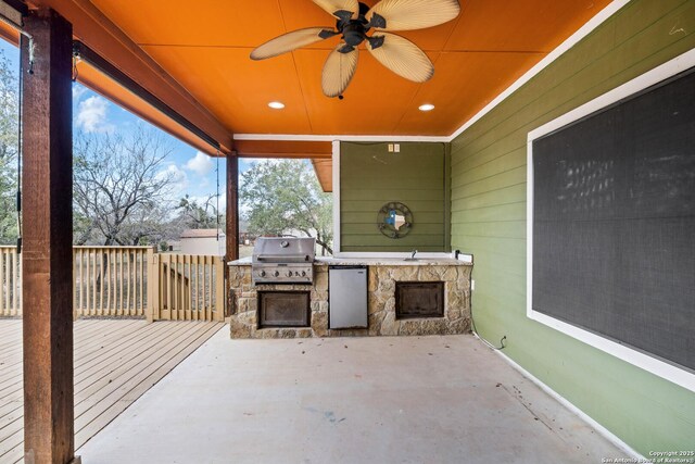 view of patio with ceiling fan, a grill, exterior kitchen, and a wooden deck