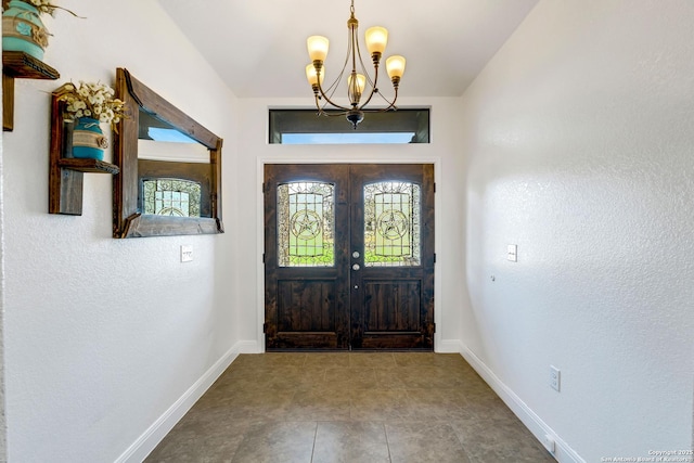 foyer featuring french doors and a notable chandelier