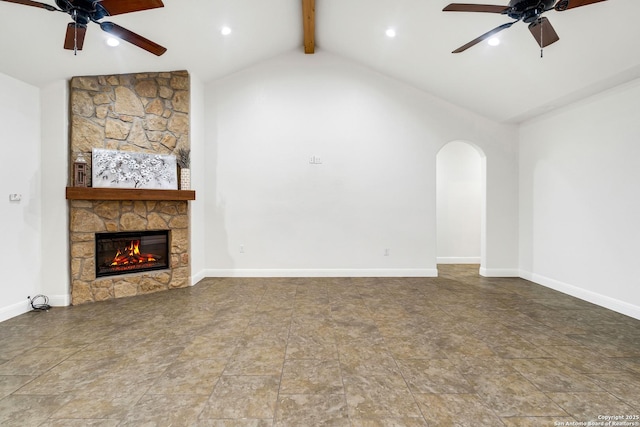 unfurnished living room featuring beam ceiling, high vaulted ceiling, a stone fireplace, and ceiling fan