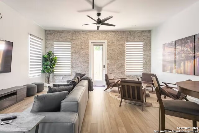 living room with light wood-type flooring and ceiling fan