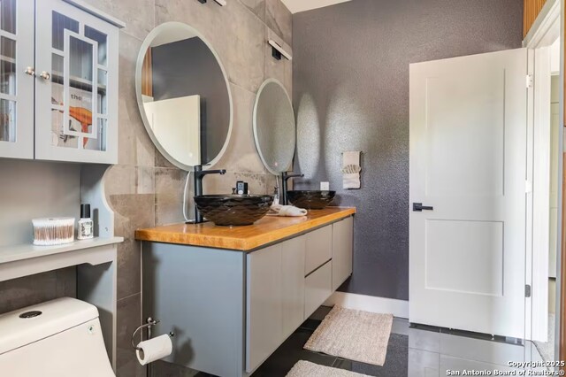 bathroom with tile patterned flooring, vanity, and toilet