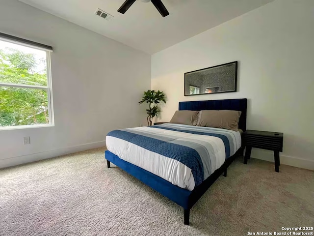 bedroom featuring multiple windows, ceiling fan, and carpet