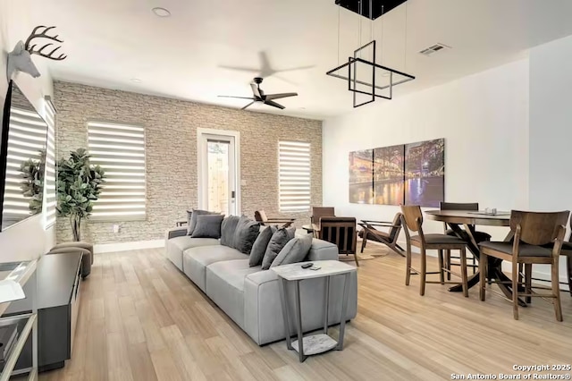 living room with ceiling fan and light hardwood / wood-style flooring