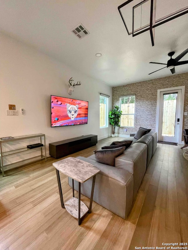 living room with light hardwood / wood-style flooring and ceiling fan