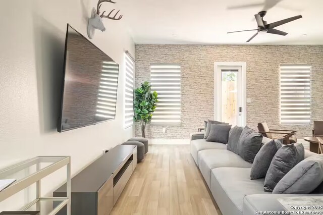 living room featuring light hardwood / wood-style floors and ceiling fan