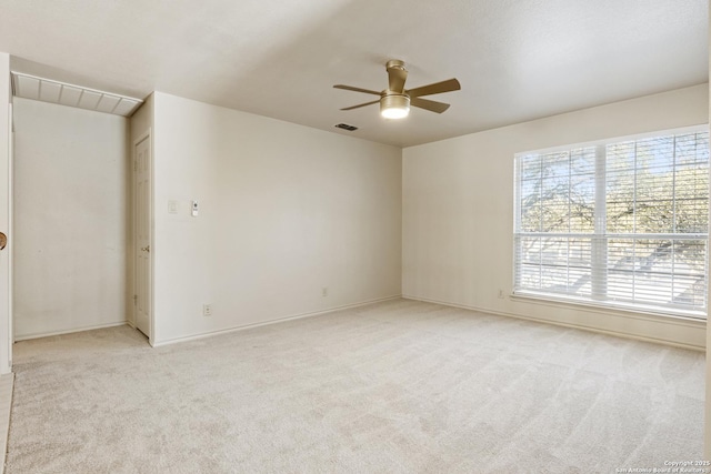 carpeted spare room featuring ceiling fan