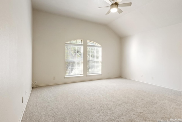 empty room with ceiling fan, carpet floors, and vaulted ceiling