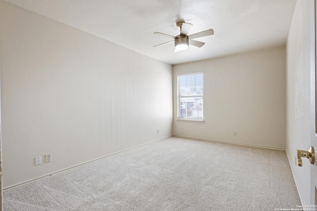 spare room with ceiling fan and light carpet