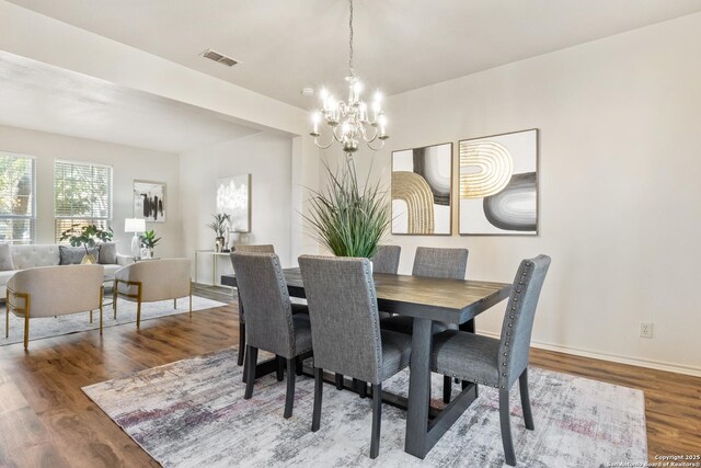 dining space featuring hardwood / wood-style flooring and a notable chandelier