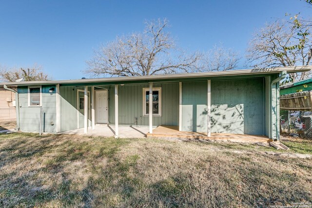 rear view of house with a lawn and a patio