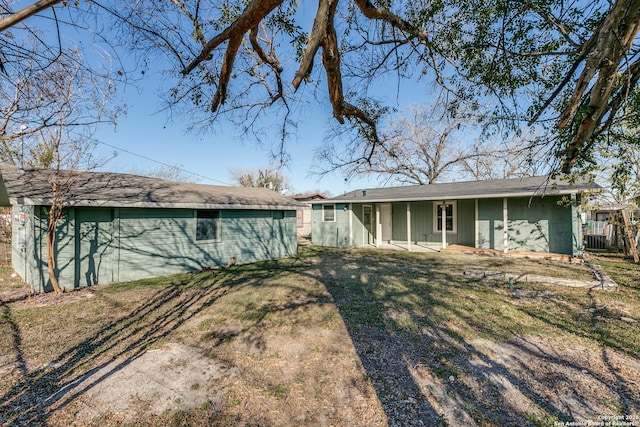 back of property featuring a lawn and central air condition unit