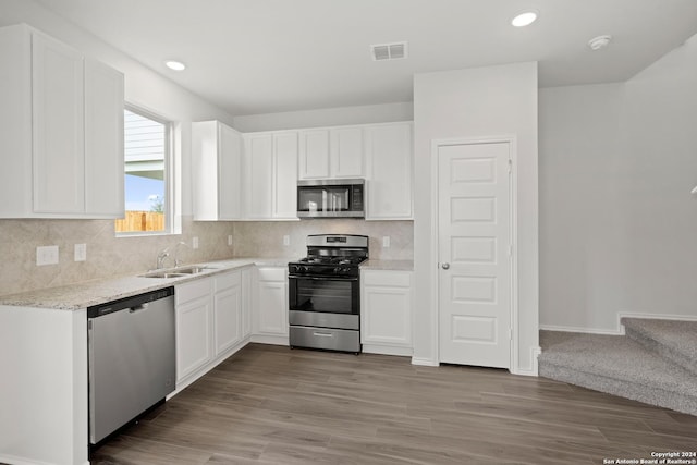 4906 Sandstone Way, San Antonio, TX 78222 - kitchen with white cabinetry, sink, light hardwood / wood-style floors, and appliances with stainless steel finishes