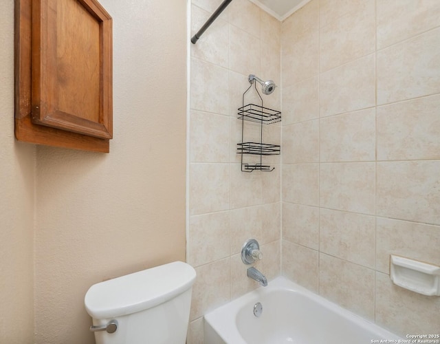 bathroom featuring tiled shower / bath combo and toilet