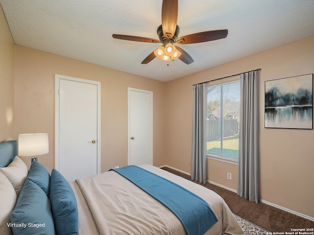 bedroom with a textured ceiling, carpet floors, and ceiling fan