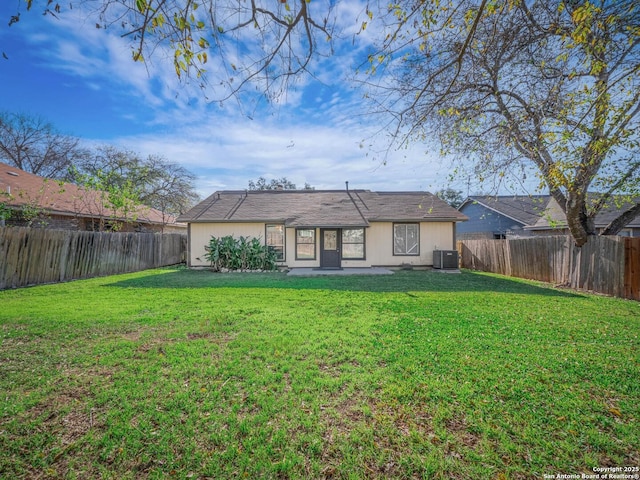 back of property with a lawn and central air condition unit