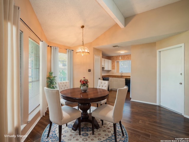 dining room with sink, vaulted ceiling with beams, dark hardwood / wood-style floors, a chandelier, and a textured ceiling