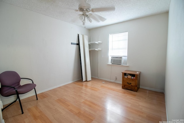 unfurnished room with a textured ceiling, light hardwood / wood-style floors, ceiling fan, and cooling unit