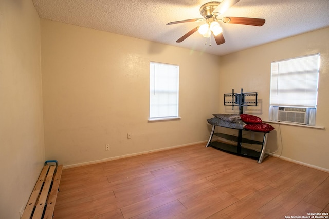 unfurnished room featuring a textured ceiling, light hardwood / wood-style floors, ceiling fan, and cooling unit