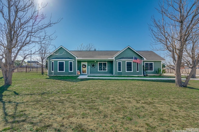 ranch-style home featuring covered porch and a front yard