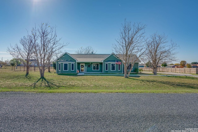 ranch-style home featuring covered porch and a front lawn