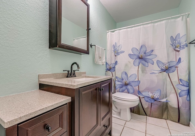 bathroom with tile patterned flooring, vanity, and toilet