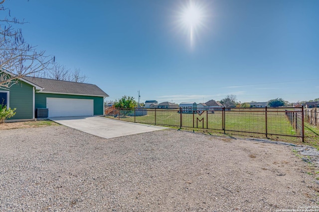 view of yard featuring central air condition unit and a garage