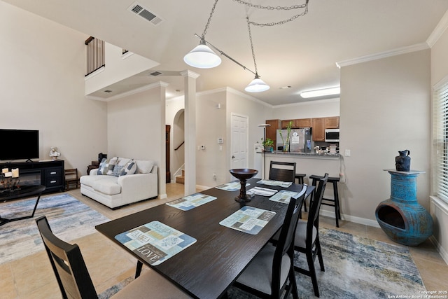 tiled dining area featuring crown molding