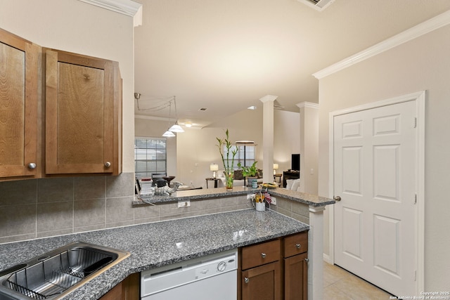 kitchen featuring dishwasher, dark stone countertops, ornamental molding, light tile patterned floors, and kitchen peninsula