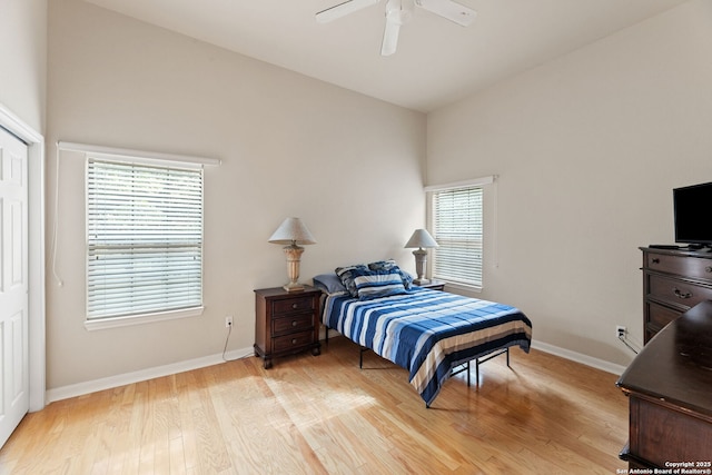 bedroom featuring ceiling fan, light hardwood / wood-style floors, and multiple windows