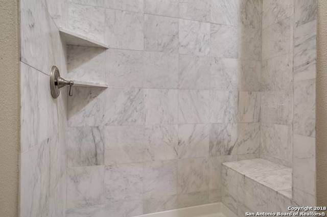 interior details with a tile shower