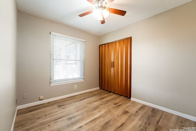 unfurnished bedroom with ceiling fan, a closet, and light hardwood / wood-style flooring