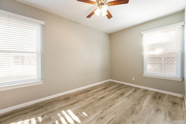 empty room with ceiling fan, a healthy amount of sunlight, and light wood-type flooring