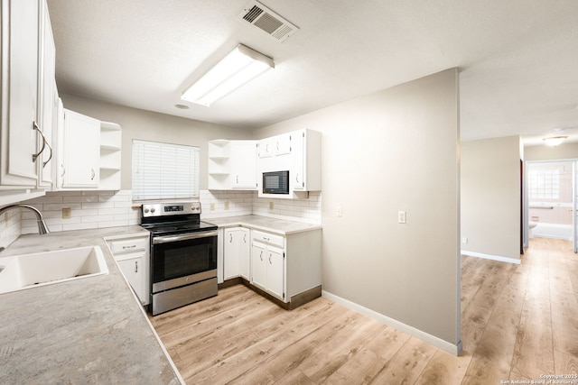 kitchen with white cabinets, sink, light hardwood / wood-style floors, and stainless steel electric range