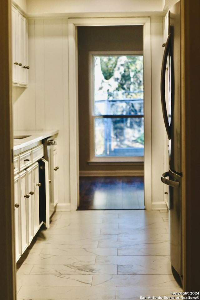 kitchen featuring white cabinets and stainless steel refrigerator