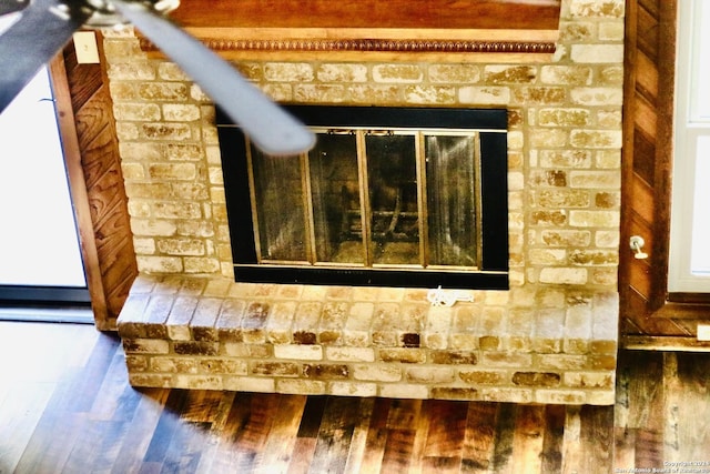 interior details featuring a brick fireplace and hardwood / wood-style floors