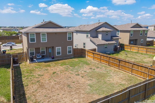 back of property with a yard and a patio