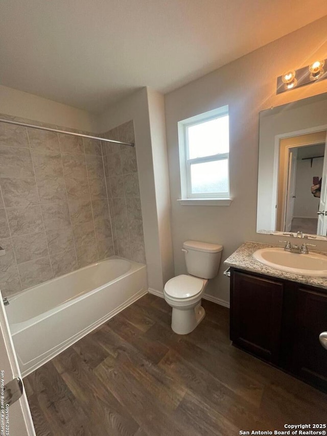 full bathroom with wood-type flooring, vanity, toilet, and tiled shower / bath