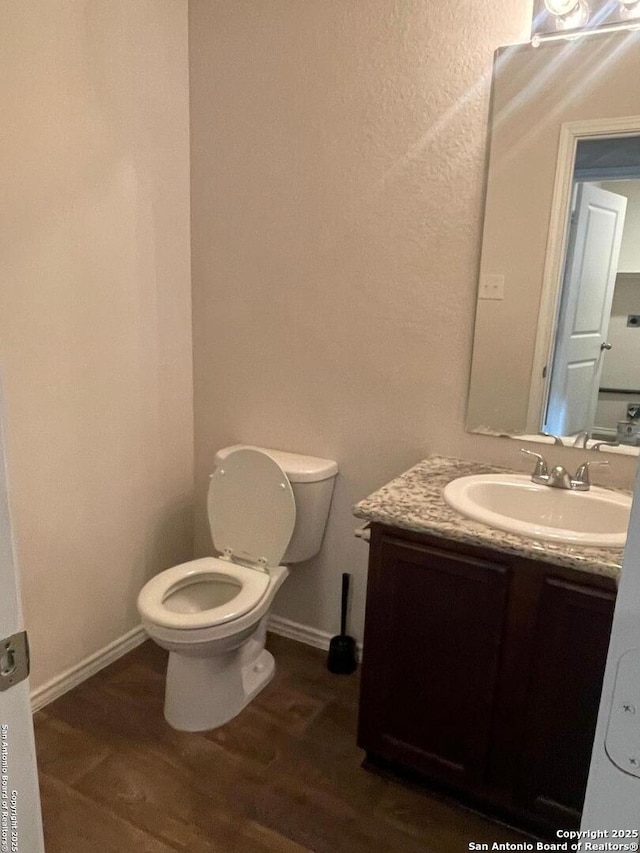 bathroom featuring vanity, toilet, and wood-type flooring