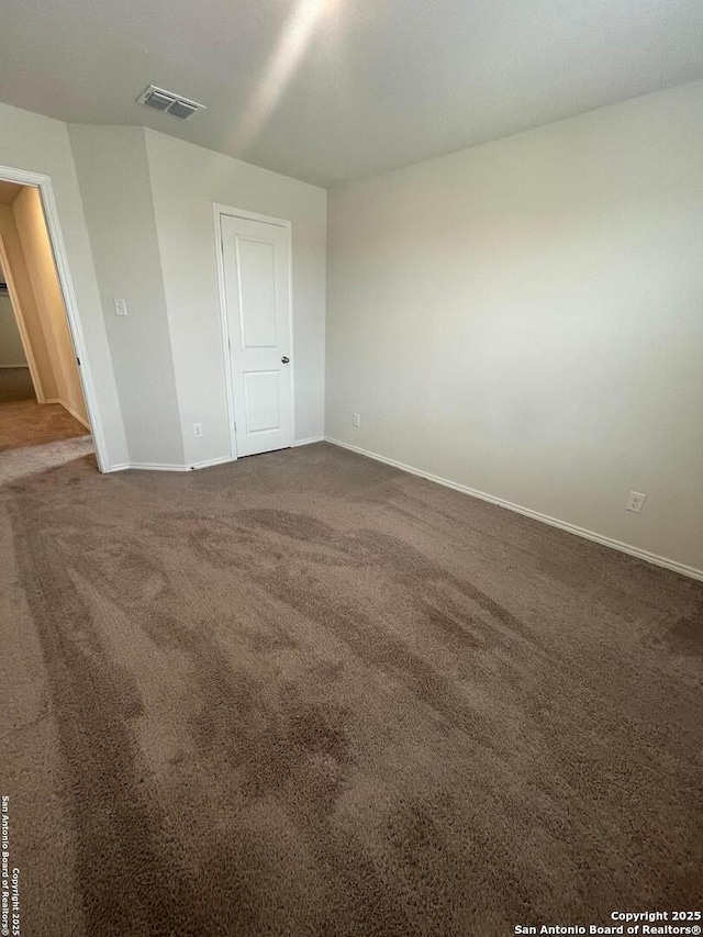 spare room with dark colored carpet