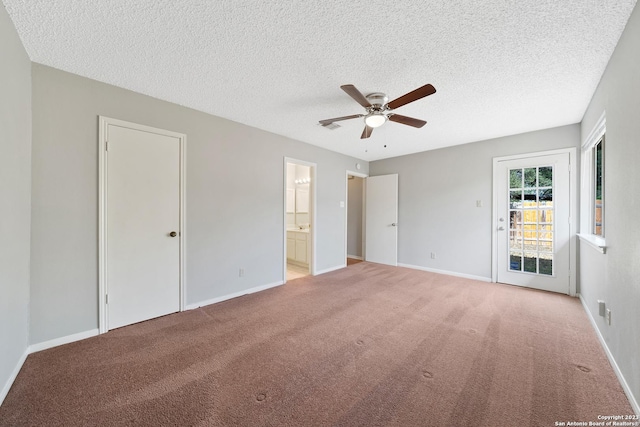 unfurnished bedroom featuring light carpet, a textured ceiling, ensuite bath, and ceiling fan