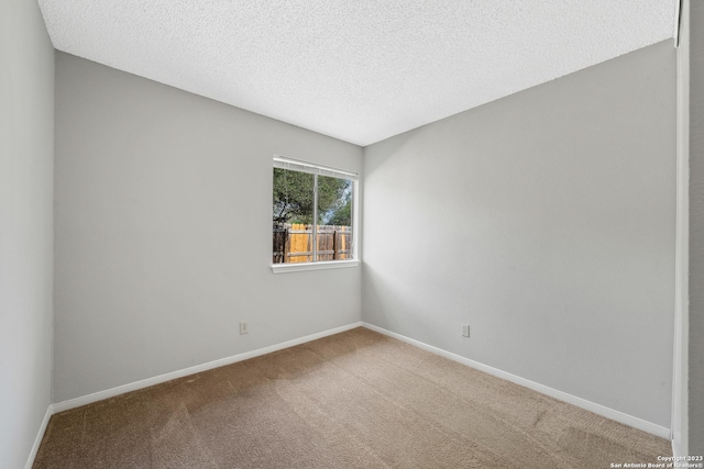 spare room with a textured ceiling and carpet floors