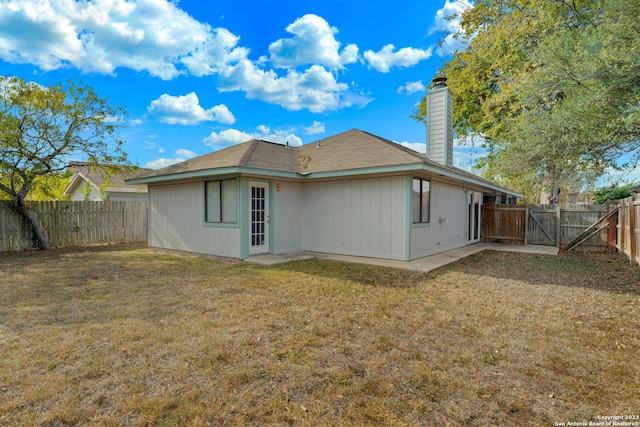 rear view of house featuring a lawn