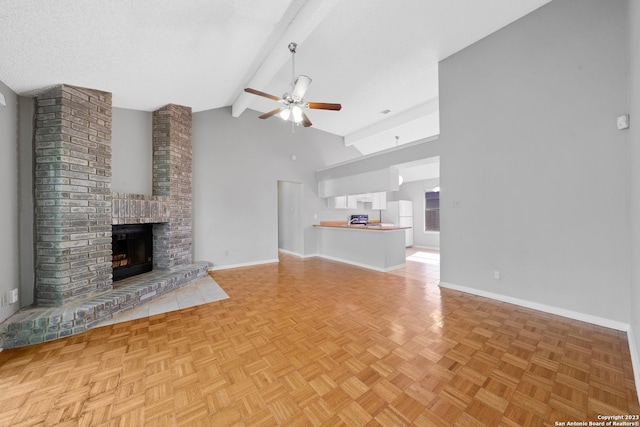 unfurnished living room featuring light parquet floors, a brick fireplace, ceiling fan, a textured ceiling, and beam ceiling